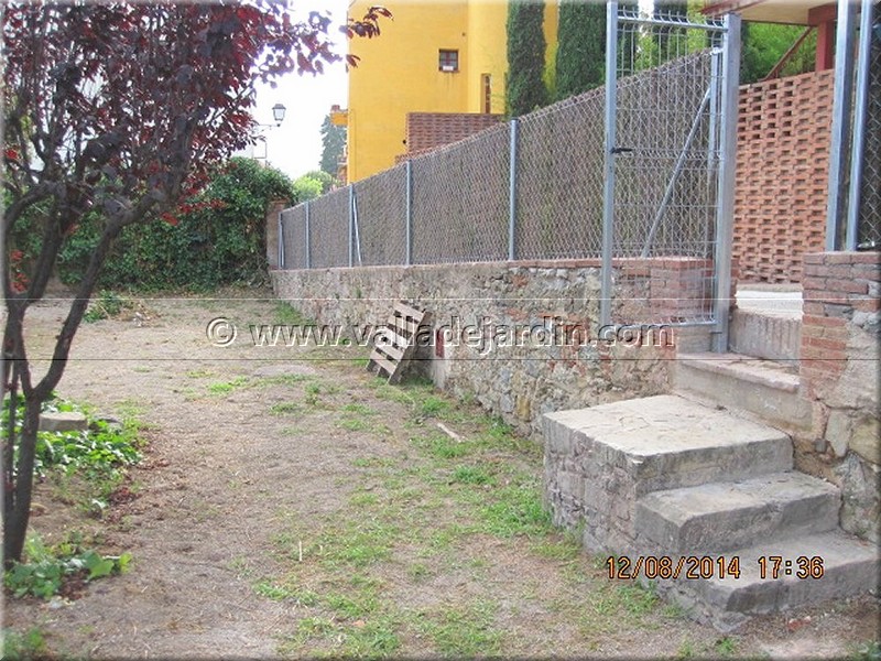 Montaje de una valla perimetral a lo largo de dos muros de contención de la  finca de un cliente particular